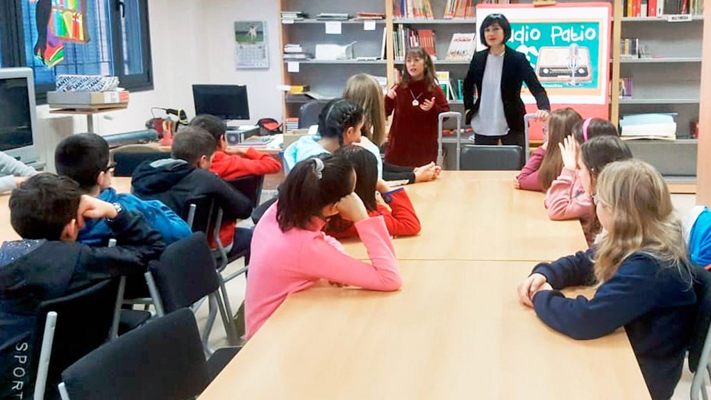 Las representantes de STE Segovia entregan las ‘Maletas viajeras’ a alumnos y profesores de La Lastrilla. / EA