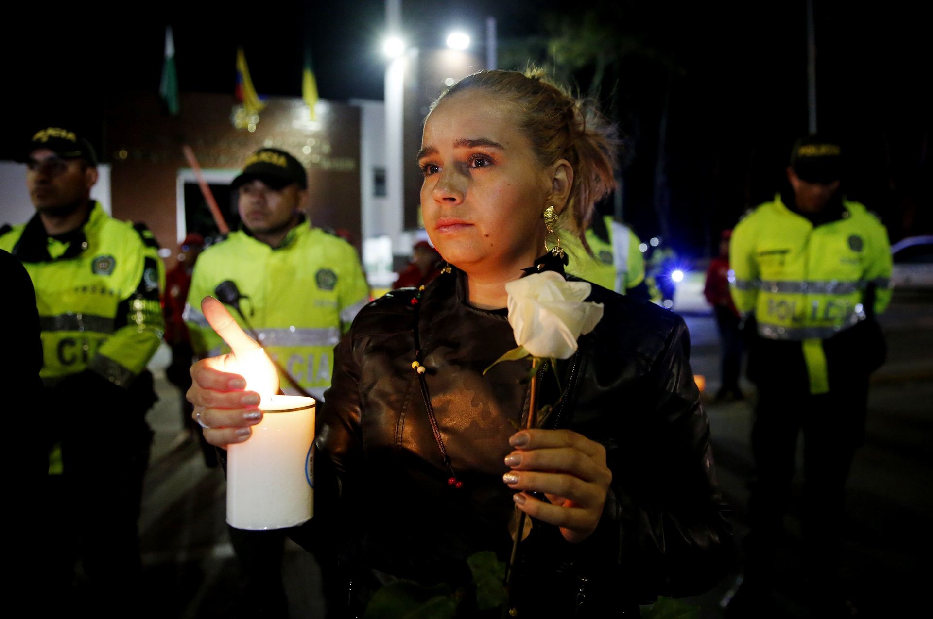 Ciudadanos y policías participan en un plantón frente a la Escuela de Policía donde murieron más de 20 personas.