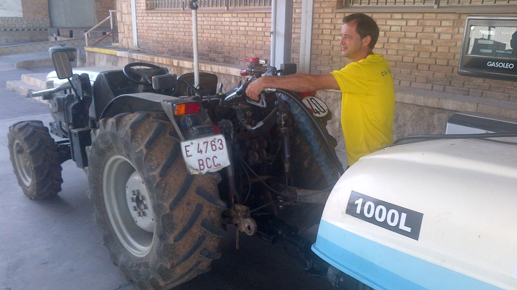 Un agricultor repostando combustible para su tractor.