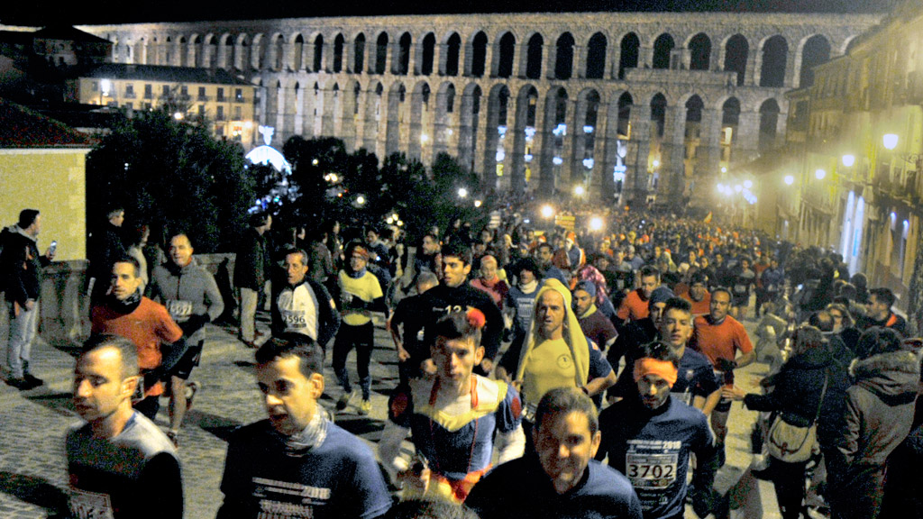 El primer paso de los deportistas por la remodelada calle san Juan, que se abrió específicamente para la ocasión, con numeroso público animando a los participantes. / KAMARERO