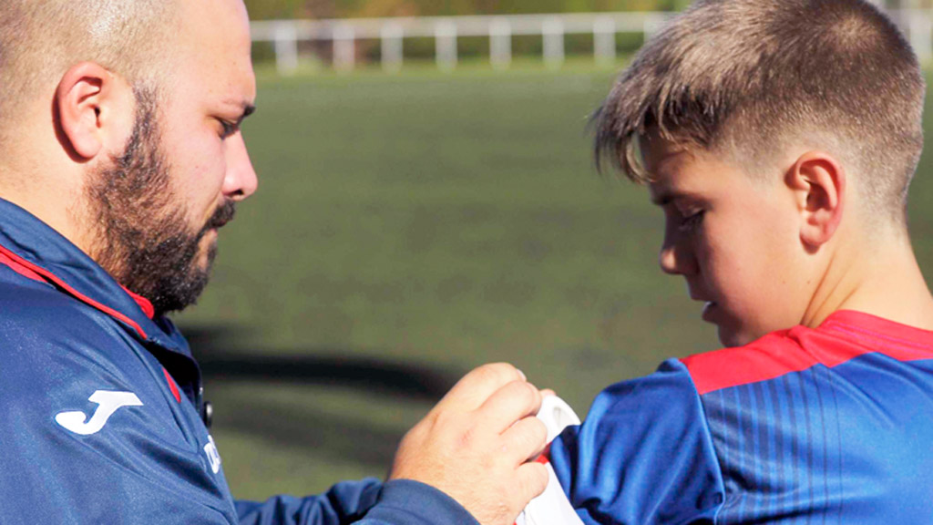 Juanjo Rica, colocando el brazalete de capitán a un jugador. / KAMARERO