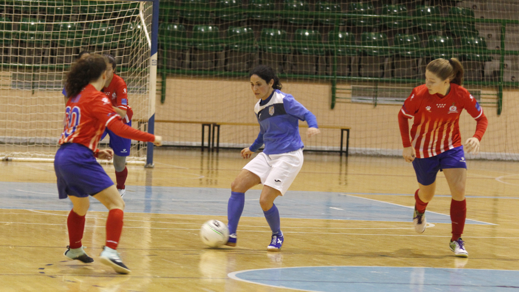 Laura Llorente intenta pasar el balón ante la oposición de dos jugadoras del Atlético Navalcarnero B. / NEREA LLORENTE