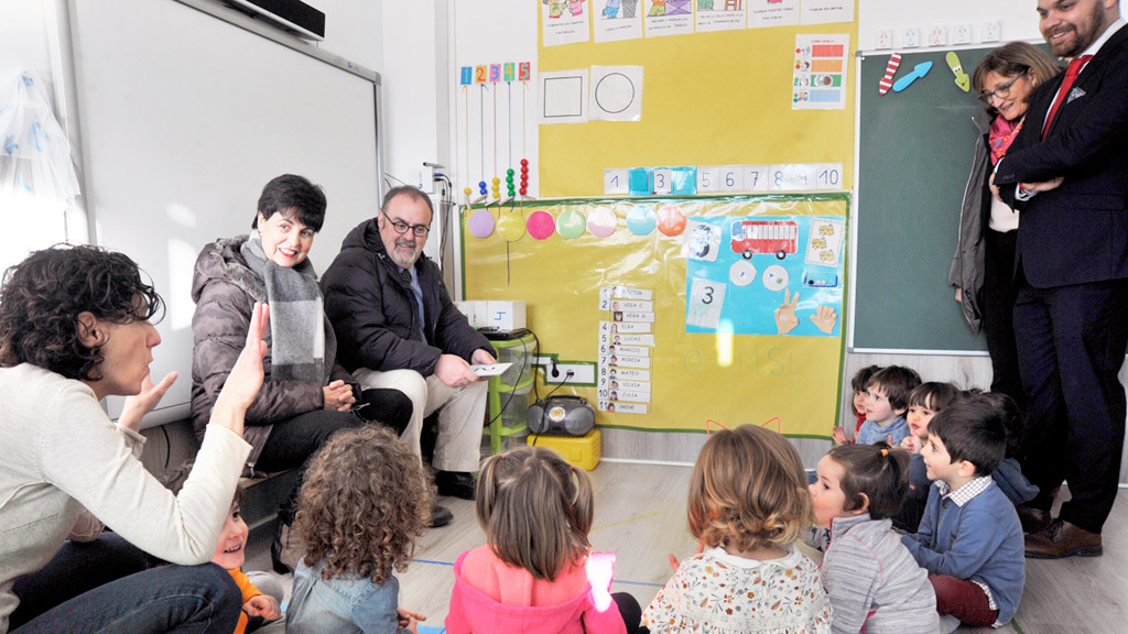 Fernando Rey y la directora del CEIP ‘Las Cañadas’, Cinta Pedrazuela, sentados junto a un grupo de escolares. / KAMARERO
