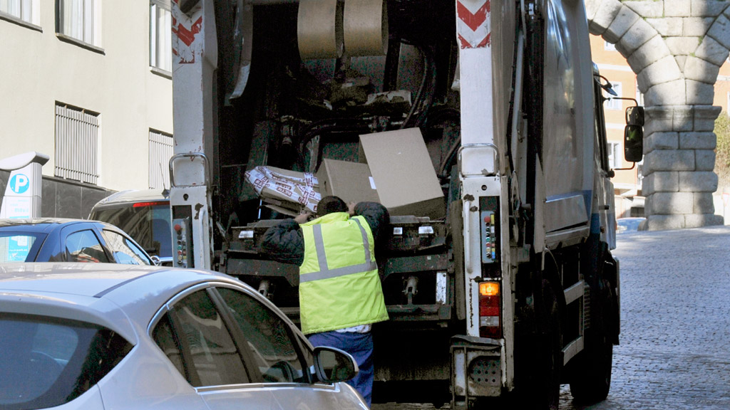 Un empleado de FCC controla el cartón depositado en uno de los camiones de recogida. / Kamarero