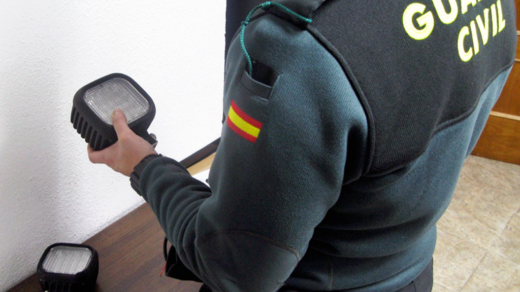 Un agente de la Guardia Civil junto a los faros sustraídos.