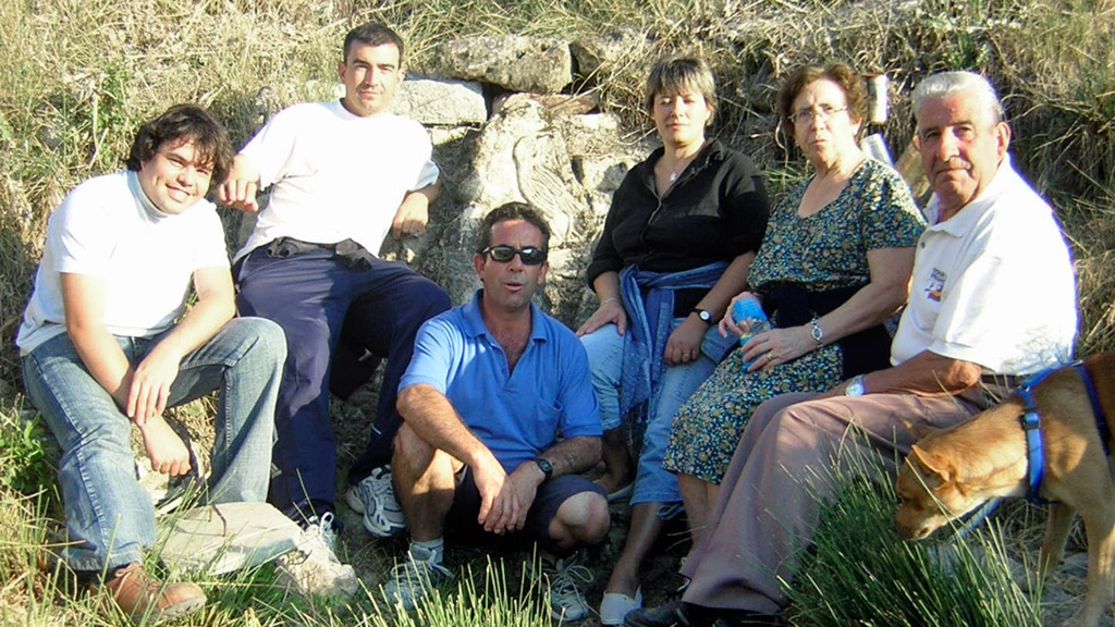 Una familia y amigos posa junto al manantial de la fuente, tras darse un paseo. /E.A.