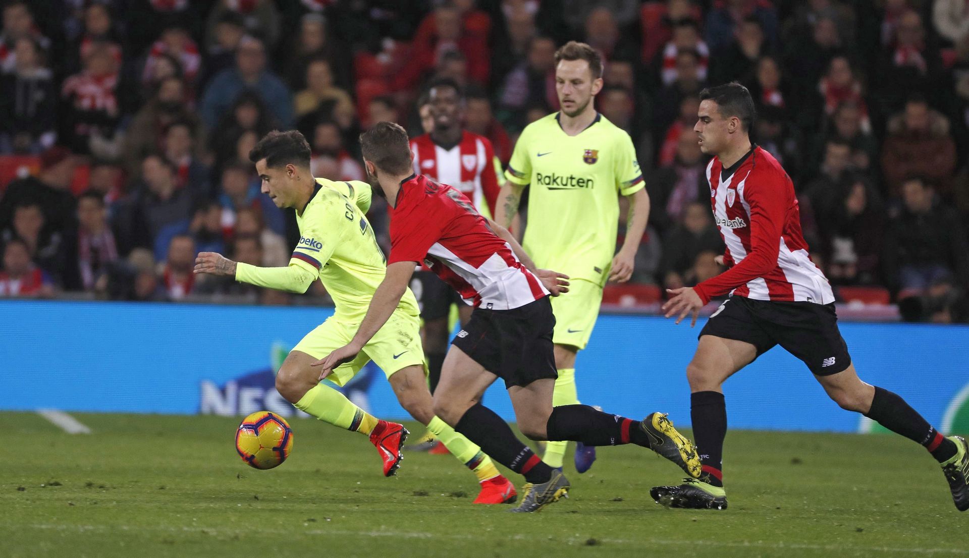 El centrocampista brasileño del Barcelona Philippe Coutinho (i), intenta zafarse de dos jugadores del Athletic Club en el partido de ayer en el estadio bilbaíno de San Mamés