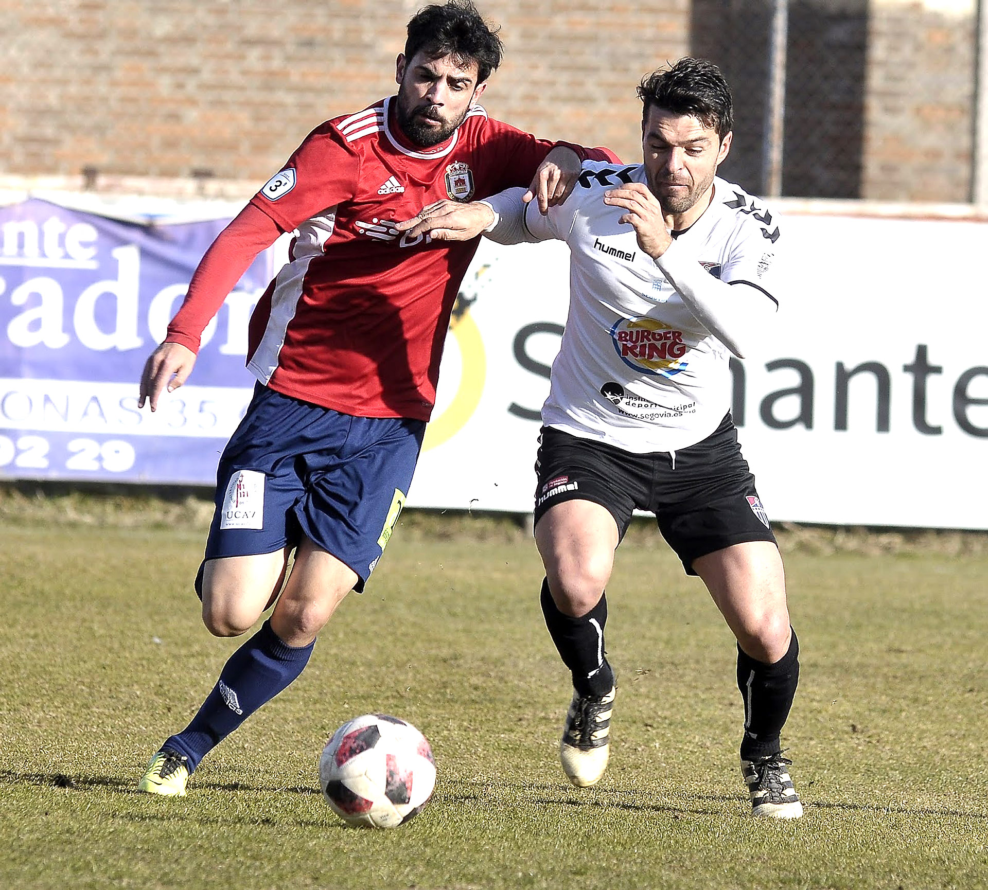 Domingo, que firmó un gran partido en el Adolfo Suárez, pelea por un balón dividido con un jugador del Real Ávila. / JUAN MARTÍN-GIMNÁSTICA SEGOVIANA