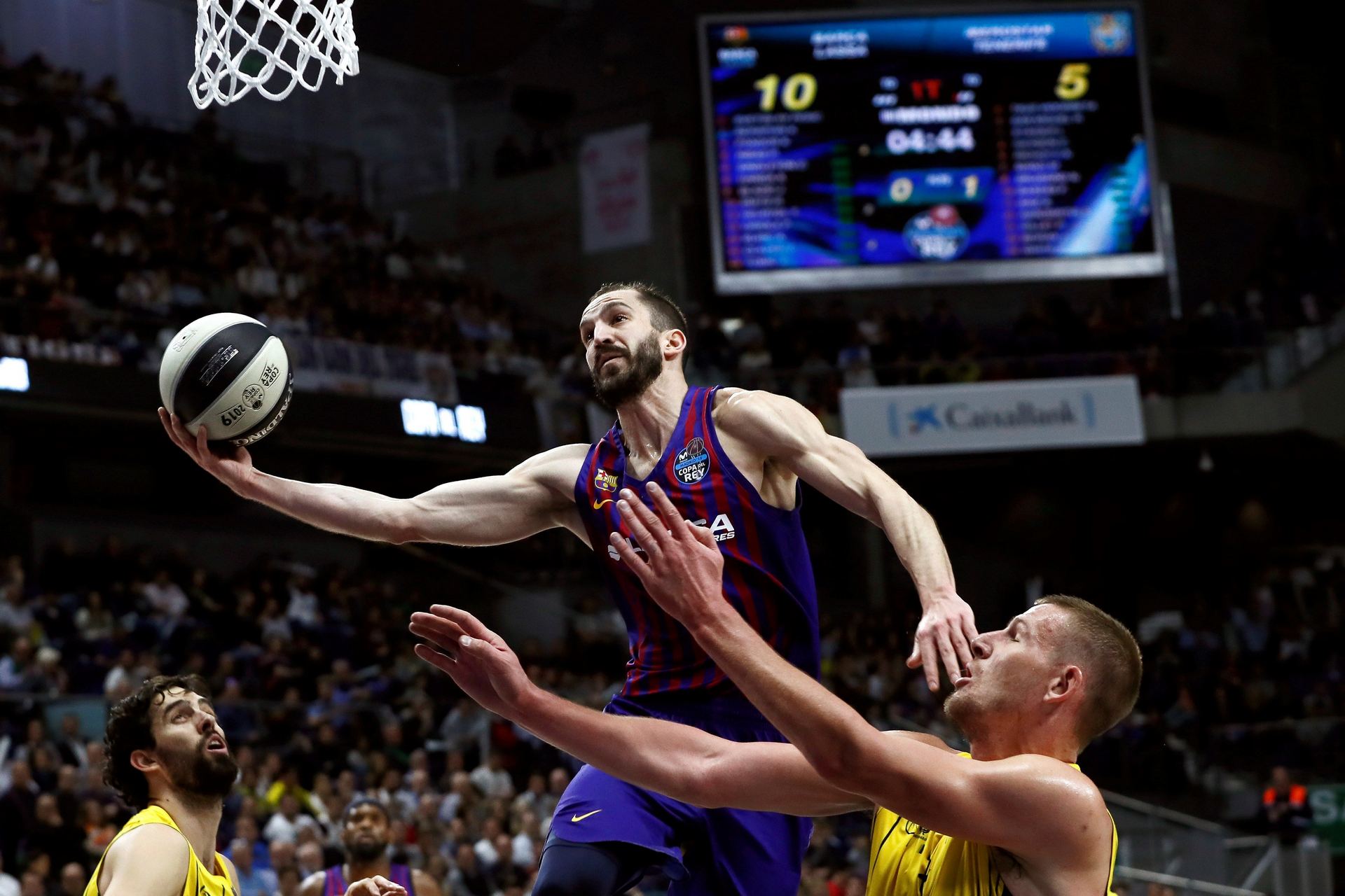 El jugador del Barcelona Lassa Pau Rivas (c) entra a canasta ante Colton Iverson (d).