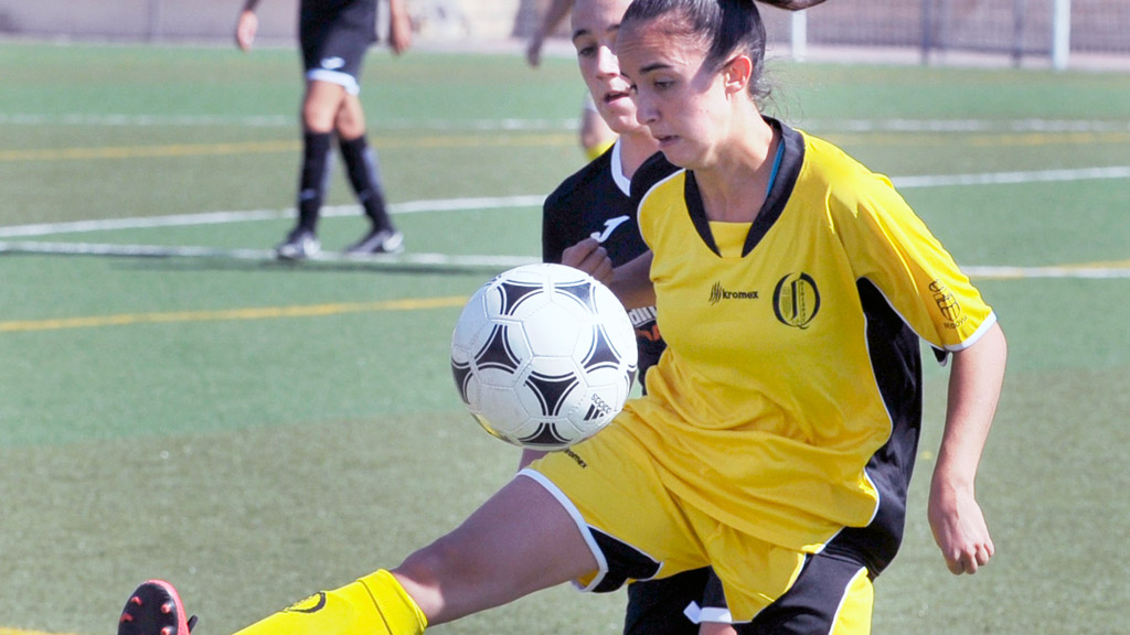 Una componente del CD Quintanar Palacio La Granja se dispone a controlar un balón ante la presión de una rival. / KAMARERO