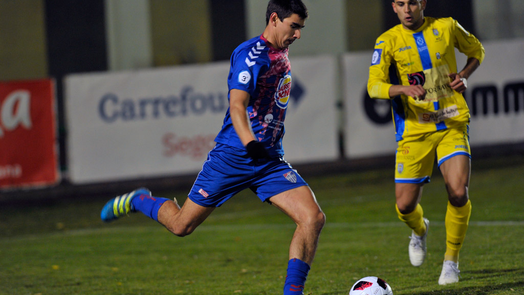 El defensa central de la Gimnástica Segovia Javi Marcos se dispone a despejar un balón. / KAMARERO