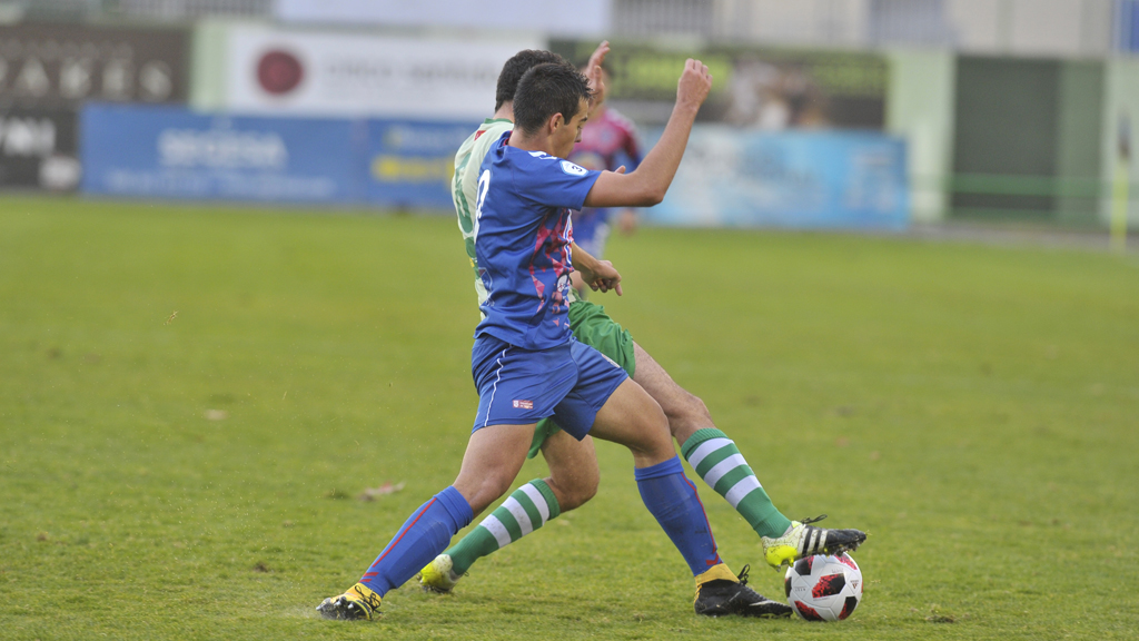 El joven delantero de la Gimnástica Segoviana Diego Gómez intenta quitar un balón a un contrincante. / KAMARERO