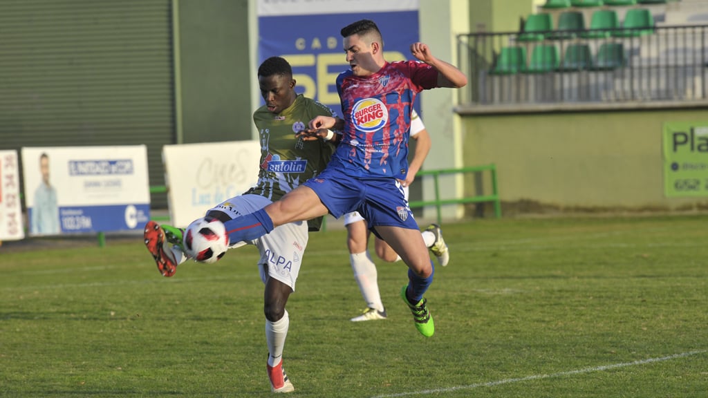 El delantero de la Gimnástica Segoviana Iván García ‘Ivi’ controla un balón ante la presión de un rival del Cristo. / KAMARERO