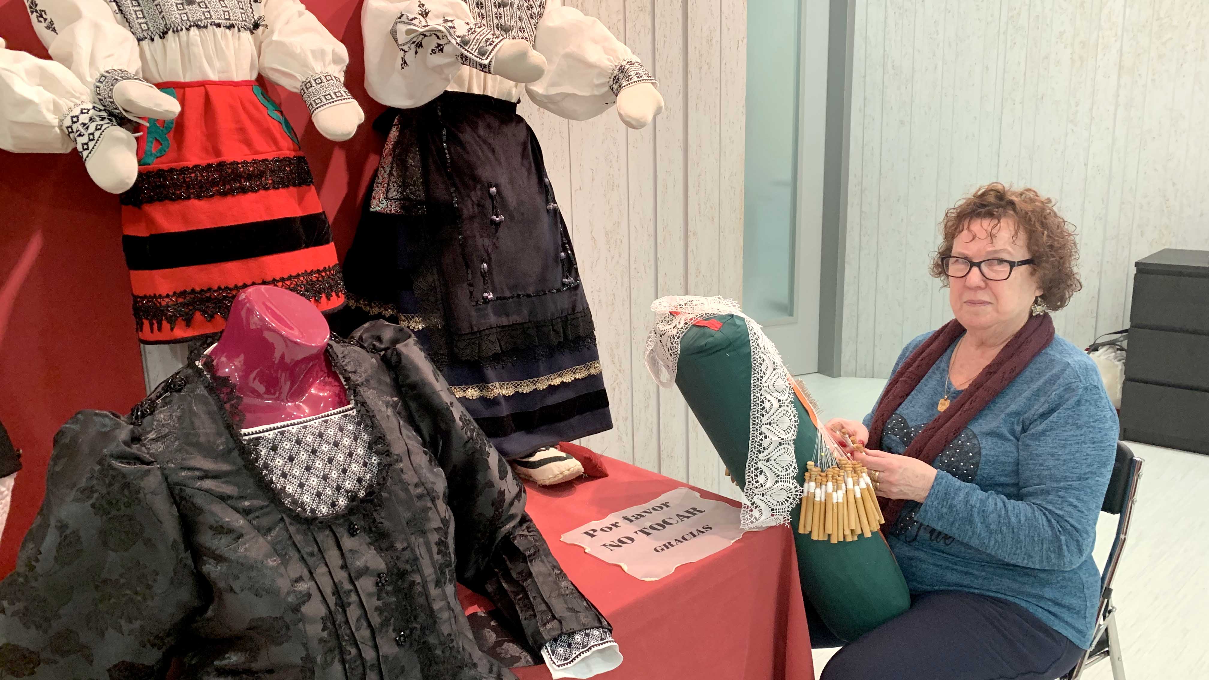 Isabel Saz junto a algunas piezas infantiles de traje regional, con sus bolillos. / c.n.