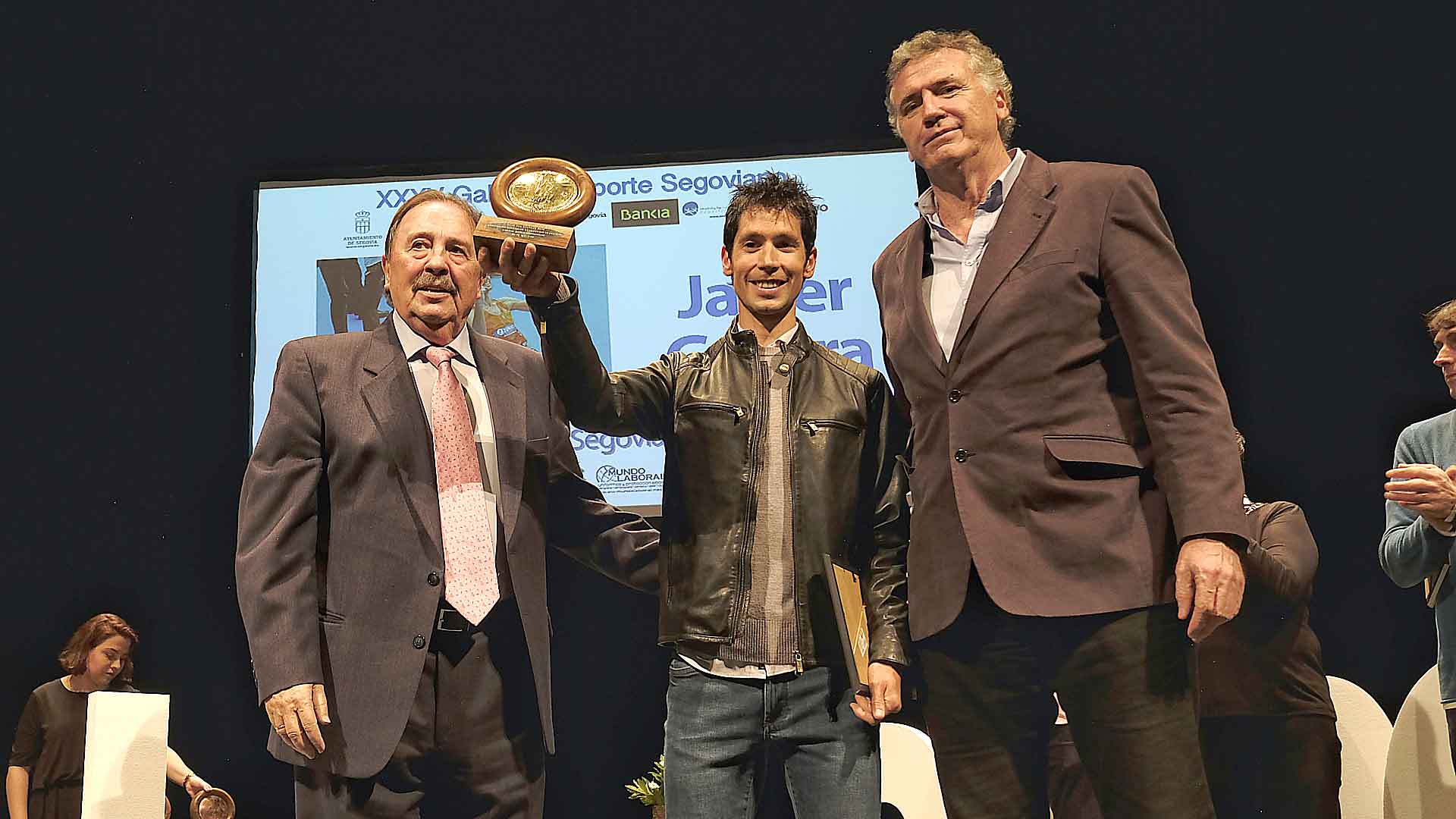 Javi Guerra, junto a Juan de Dios Román y Cecilio Alonso, muestra el galardon que le acredita como Mejor Deportista Segoviano de 2018/ KAMARERO