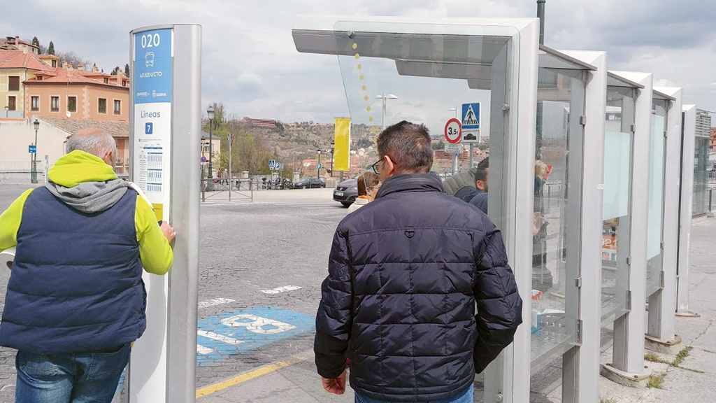 Varios operarios procedieron a cambiar ayer domingo la información de horarios y recorridos en postes y marquesinas. / E. A.