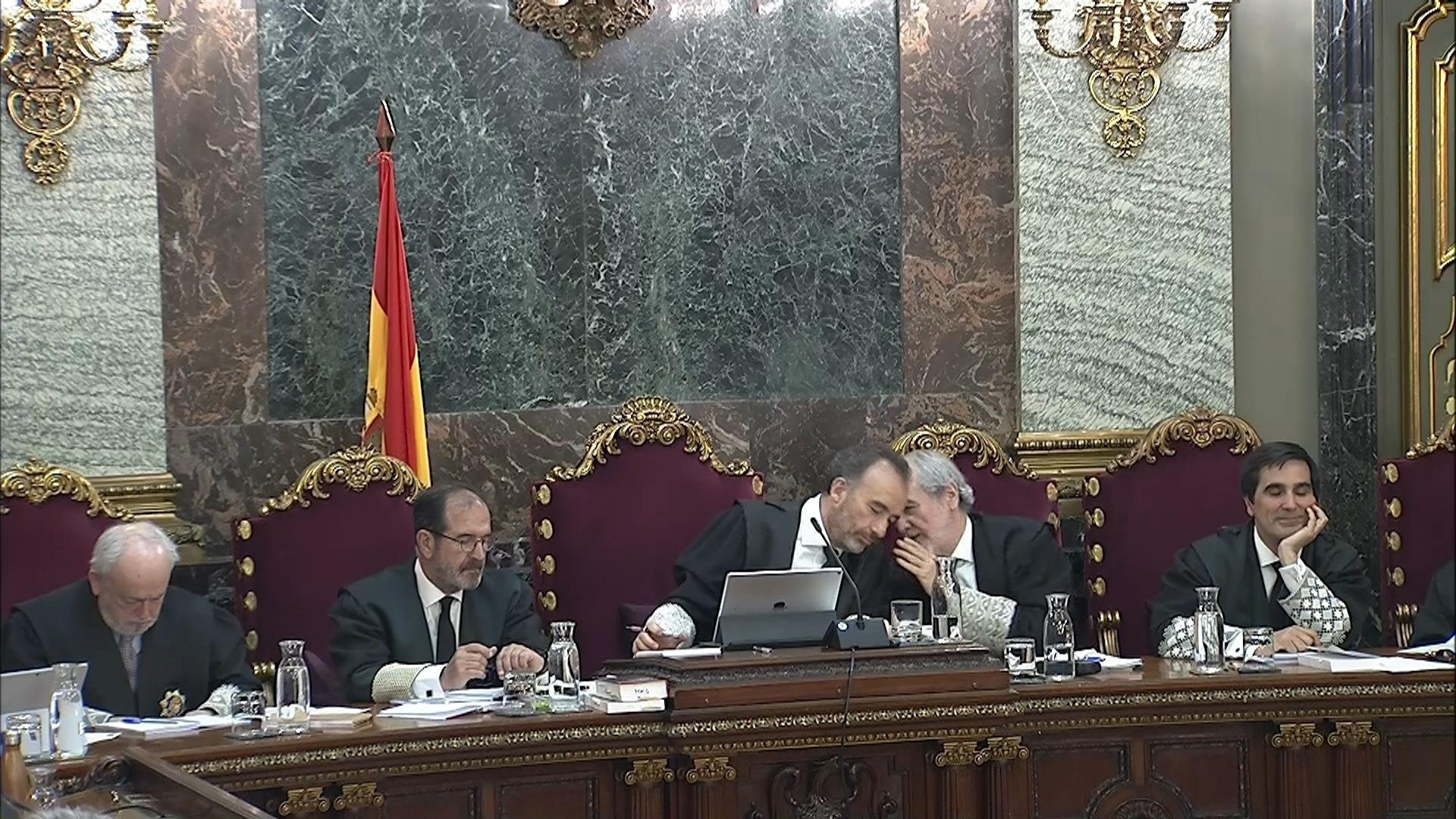 El presidente del tribunal, Manuel Marchena (3i) conversa con el juez Juan Ramón Verdugo (2d).