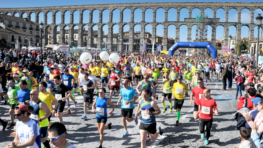 Los más de 2.300 corredores que participaron en la media maratón ‘Ciudad de Segovia’ toman salida desde los pies del Acueducto para continuar por Vía Roma. / KAMARERO