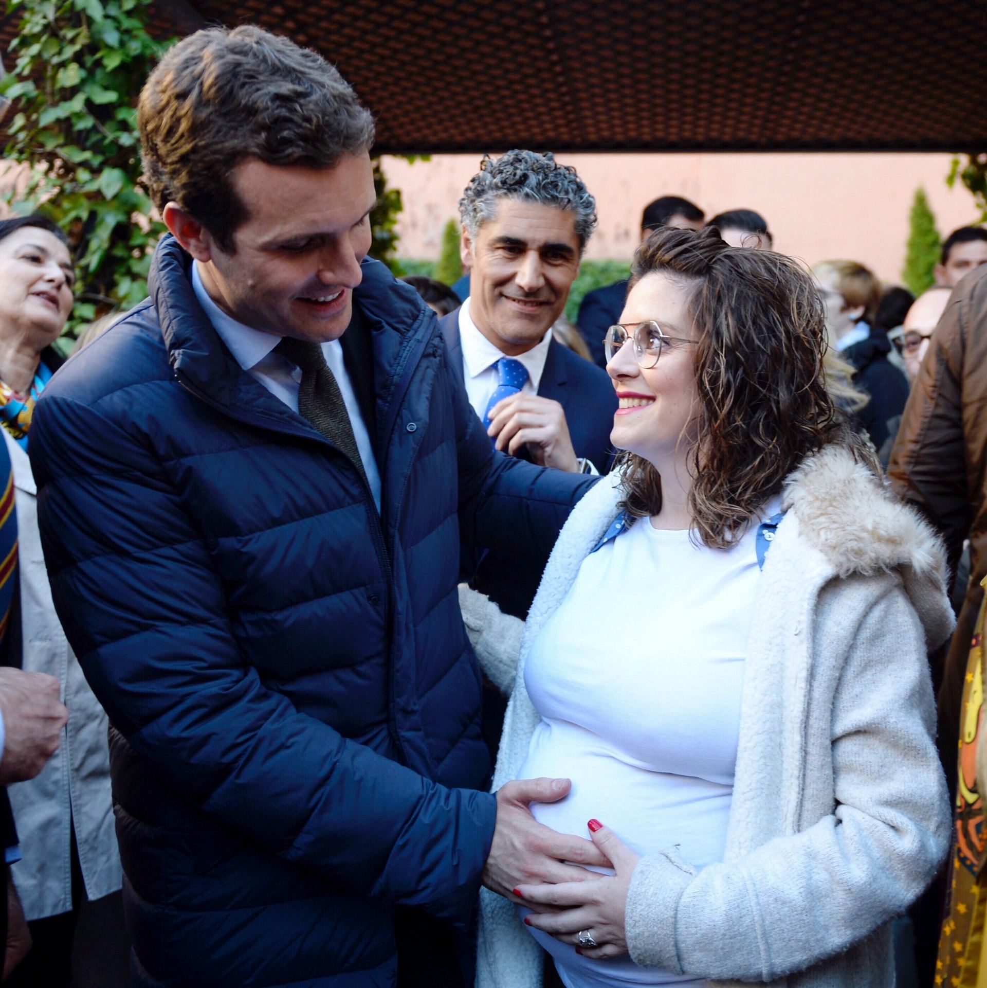 El presidente del PP, Pablo Casado (i), pone la mano en la barriga de una embarazada durante su recorrido por las calles de Valladolid.