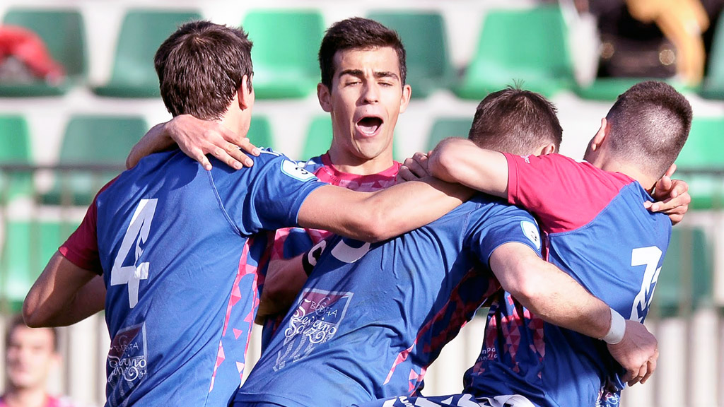 Javi Marcos, Gómez y Mika abrazan a Anel después de que el capitán de la Segoviana consiguiera el primer gol del partido. / JUAN MARTÍN-GIMNÁSTICA SEGOVIANA