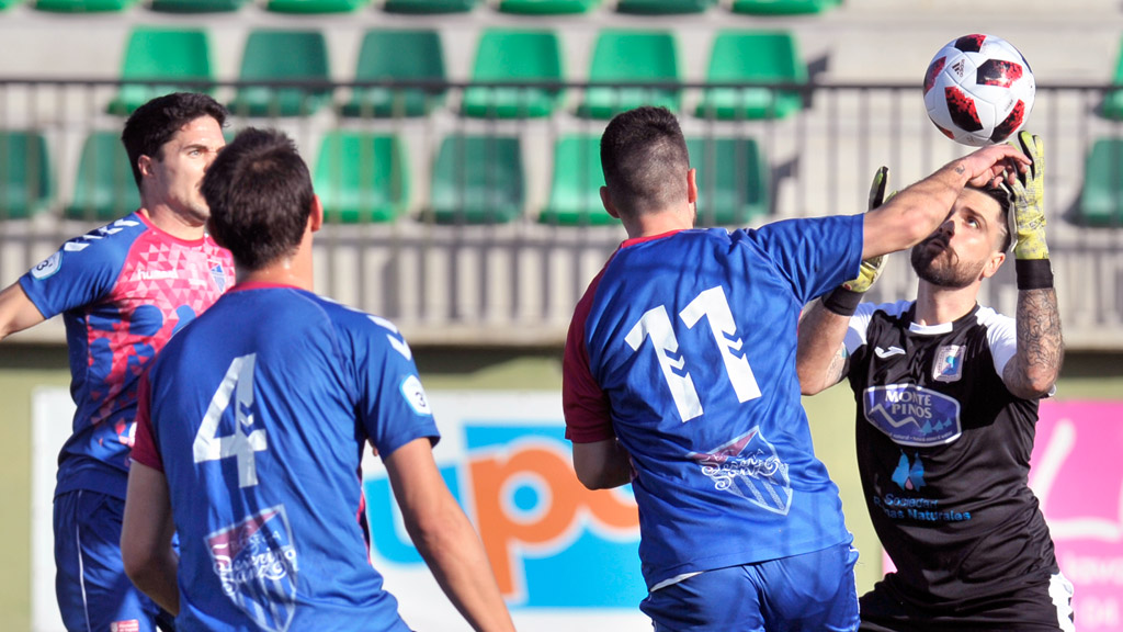 El portero del Almazán, Álvaro, se hace con el balón ante la presencia de Mika, Rubén y Javi Marcos en uno de los múltiples ataques de la Segoviana sobre el marco soriano. / KAMARERO