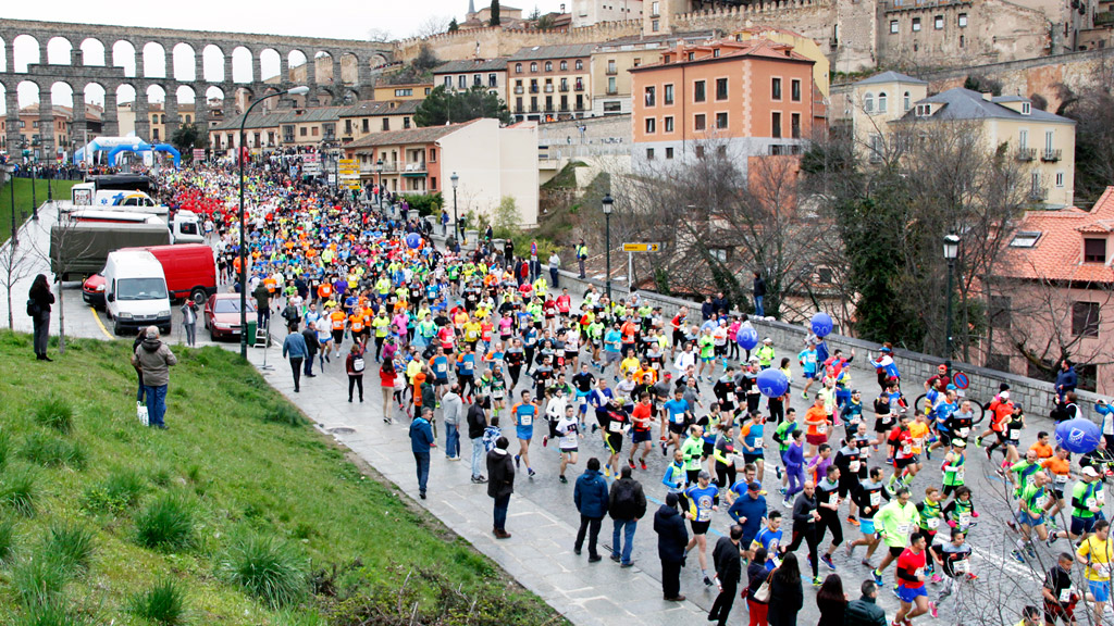 Centenares de corredores toman salida desde el Acueducto y bajan Vía Roma, en una pasada edición de la media maratón ‘Ciudad de Segovia’. / NEREA LLORENTE