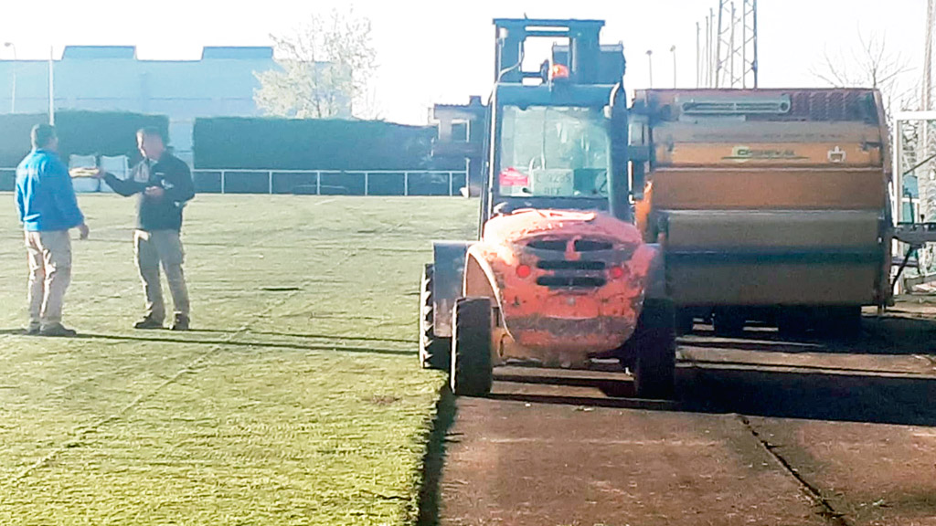 Una de las máquinas, comenzando a desmontar el césped artificial del Mariano Chocolate. / EL ADELANTADO