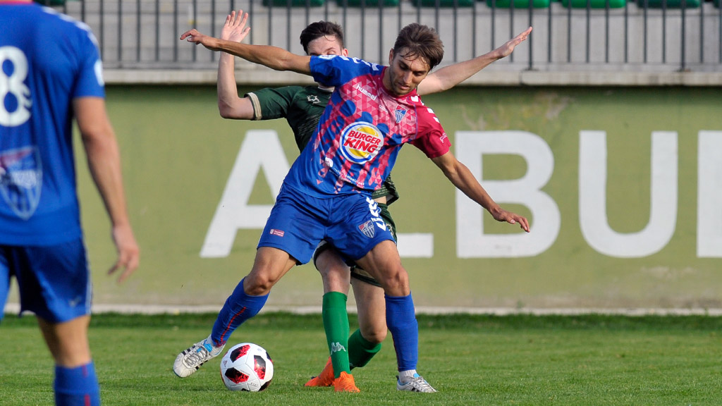 El jugador de la Gimnástica Segoviana Álex Conde controla un balón ante la presión de un contrincante del Atlético Astorga. / KAMARERO
