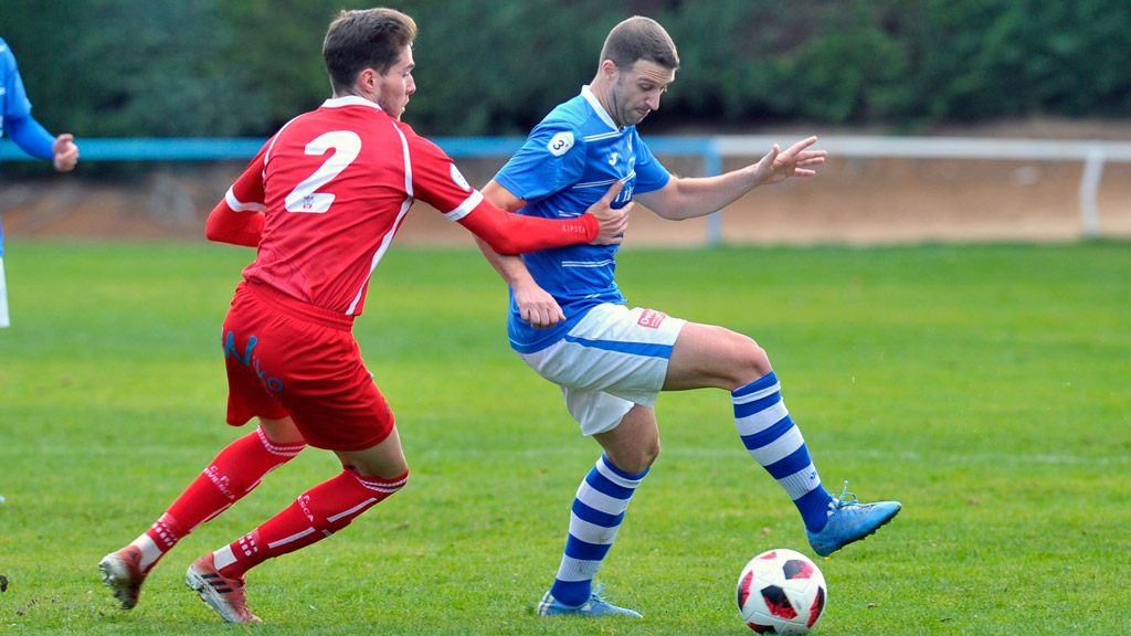 Mario intenta superar el marcaje de un jugador del Briviesca. / KAMARERO