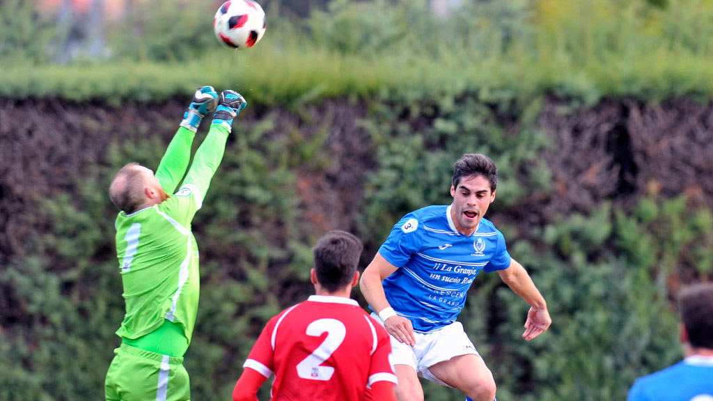 El defensa del CD La Granja Enrique Llorente ‘Kike’ salta con la intención de rematar ante el portero del Briviesca. / KAMARERO