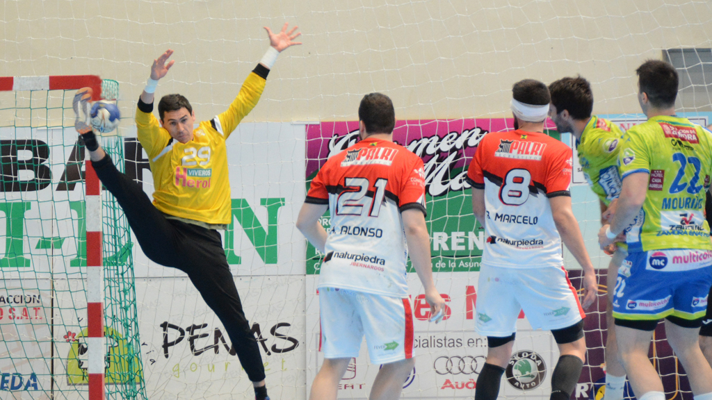 Yeray Lamariano  eleva la pierna a la altura de su cabeza para rechazar el lanzamiento del jugador del MMT Zamora en un momento del partido jugado en Nava de la Asunción. / AMADOR MARUGÁN