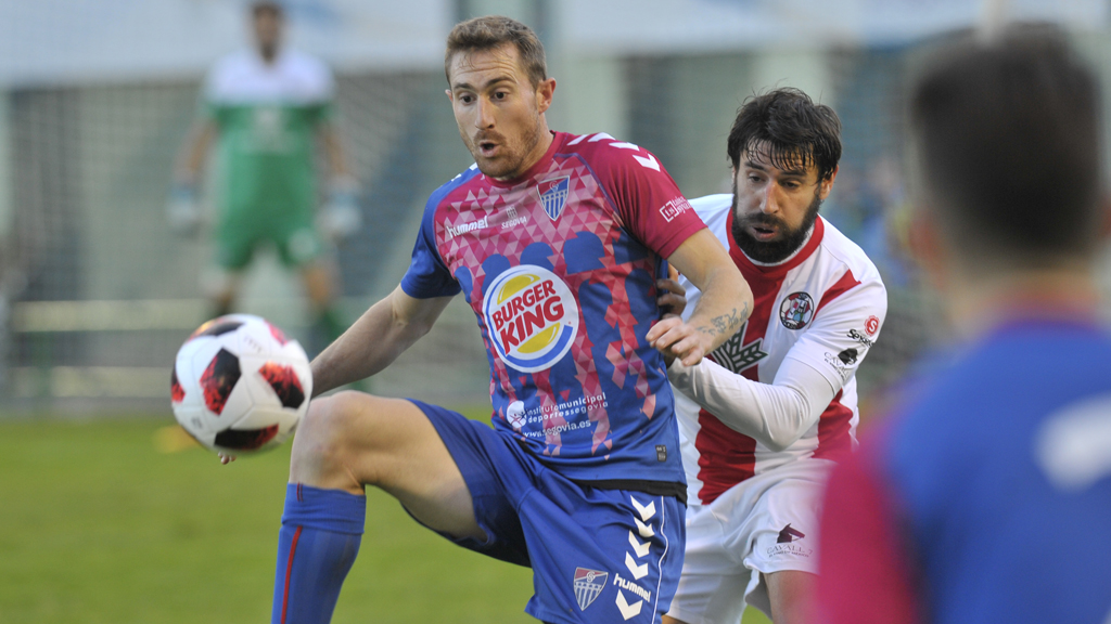 El delantero de la Gimnástica Segoviana Dani Arribas controla un balón ante la presión de un jugador del Zamora. / KAMARERO