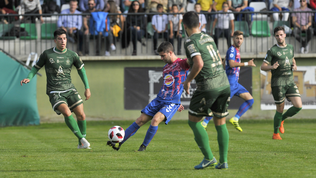 El centrocampista de la Gimnástica Segoviana Manuel Olmedilla ‘Manu’ mete un balón en largo a sus compañeros ante la presión del Atlético Astorga. / KAMARERO