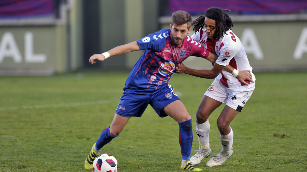 Calleja trata de zafarse del marcaje de un jugador del Zamora durante el partido de ida jugado en La Albuera. / KAMARERO