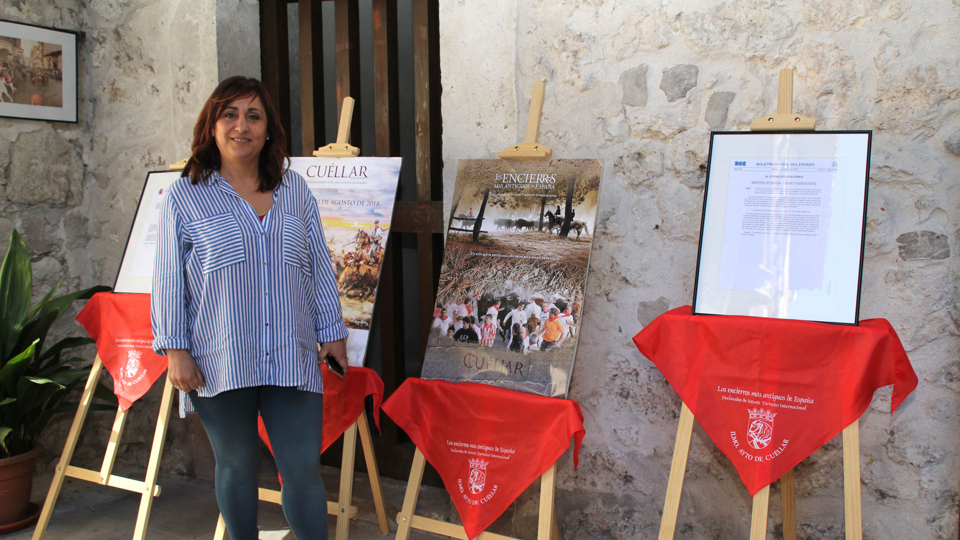 Nuria Fernández, concejal de Turismo, junto a parte de la exposición del patio del Ayuntamiento.
