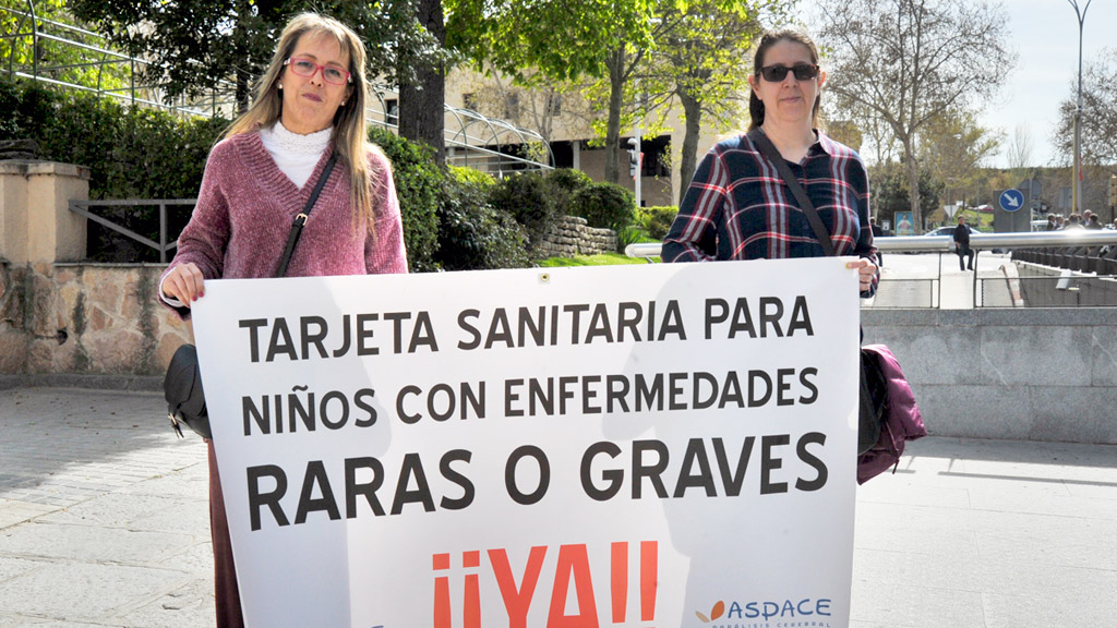 Las representantes de Aspace Segovia acuden con su pancarta a los actos de los políticos nacionales. / KAMARERO