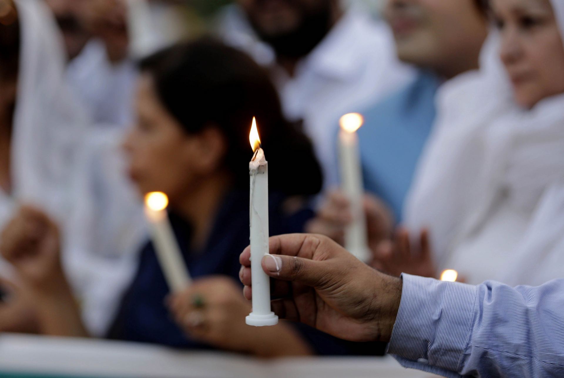 Varios activistas encienden velas en homenaje a las víctimas.