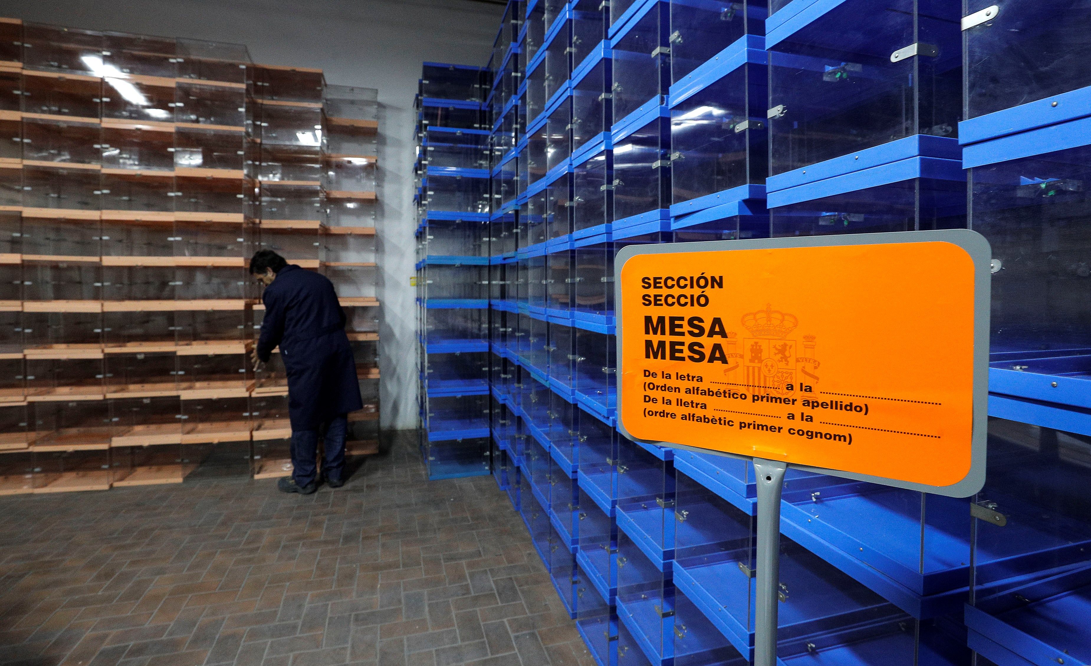 Un funcionario coloca varias urnas para los comicios de hoy en las dependencias de un colegio electoral.