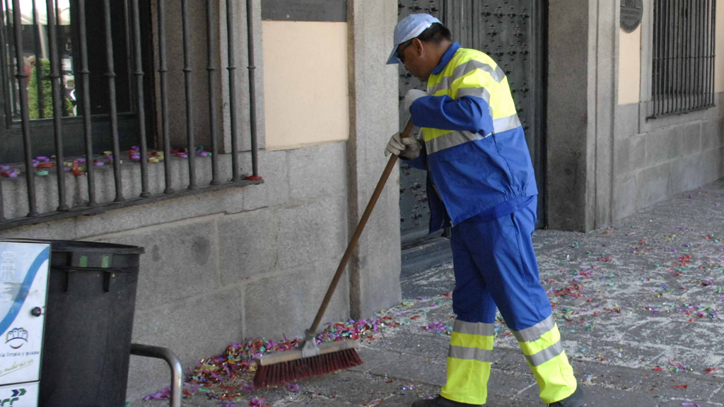 Un operario de la concesionaria de la limpieza viaria retira restos de confeti y arroz después de una boda. / Juan Martín