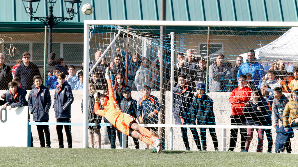 Un portero se lanza a su derecha mientras observa cómo el balón enviado por un contrario se marcha por encima de su portería. / NEREA LLORENTE