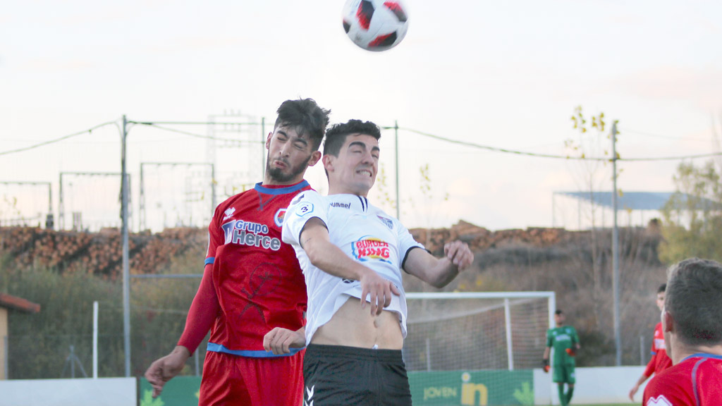 El delantero de la Gimnástica Segovia Ivi disputa un balón por alto frente a un jugador del Numancia B, en el partido de la primera vuelta disputado en Soria. / E.A.