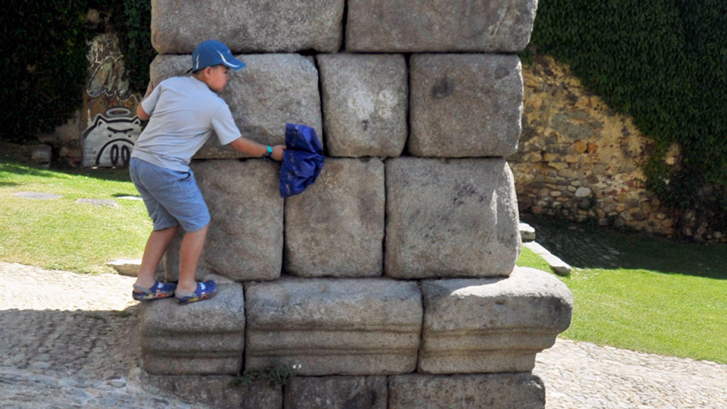 Un niño subido a los sillares del monumento. / Kamarero