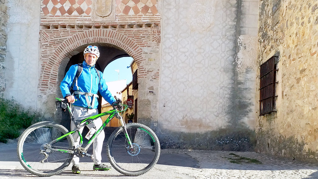 Javier Carracedo, con su bicicleta, en la localidad de Pedraza, una de las dos en las que imparte clases. / E. A.