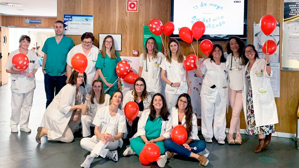 Profesionales del Servicio de Pediatría, del aula hospitalaria y de otras unidades posan con globos que llevan besos. / E. A.