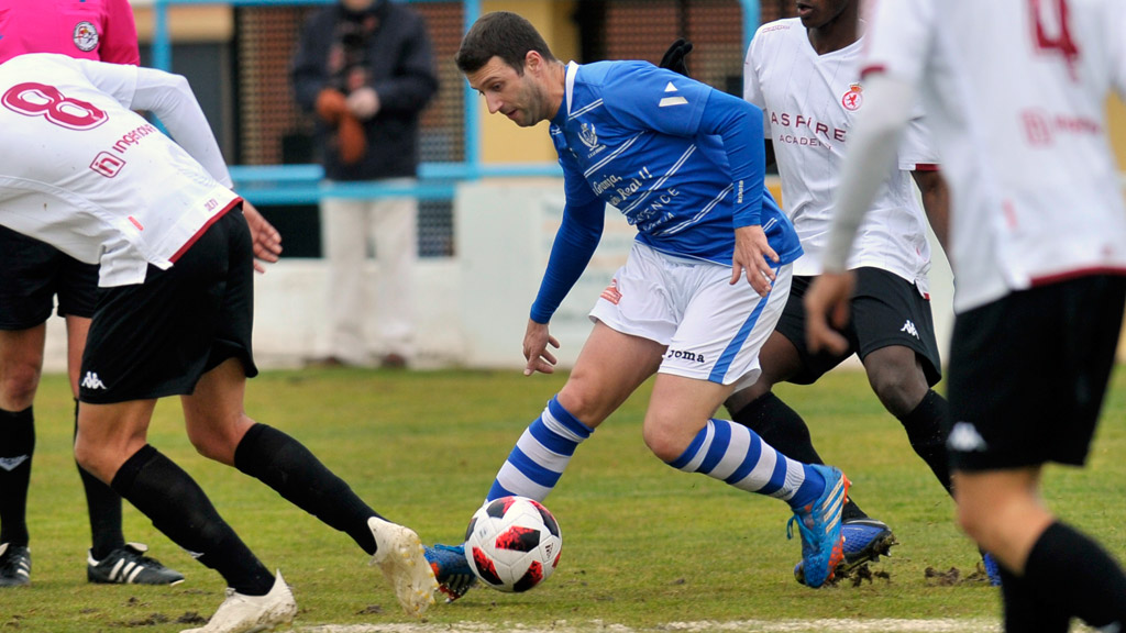 El jugador del CD La Granja Mario Zúñiga trata de marcharse de dos contrincantes del Júpiter Leonés. / KAMARERO
