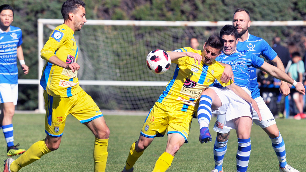 El centrocampista del CD La Granja Jesús Horcajo ‘Chechu’ intenta cortar una jugada impulsada por el atacante de la Arandina Asier Barahona, en el partido disputado en el campo de El Hospital. / KAMARERO