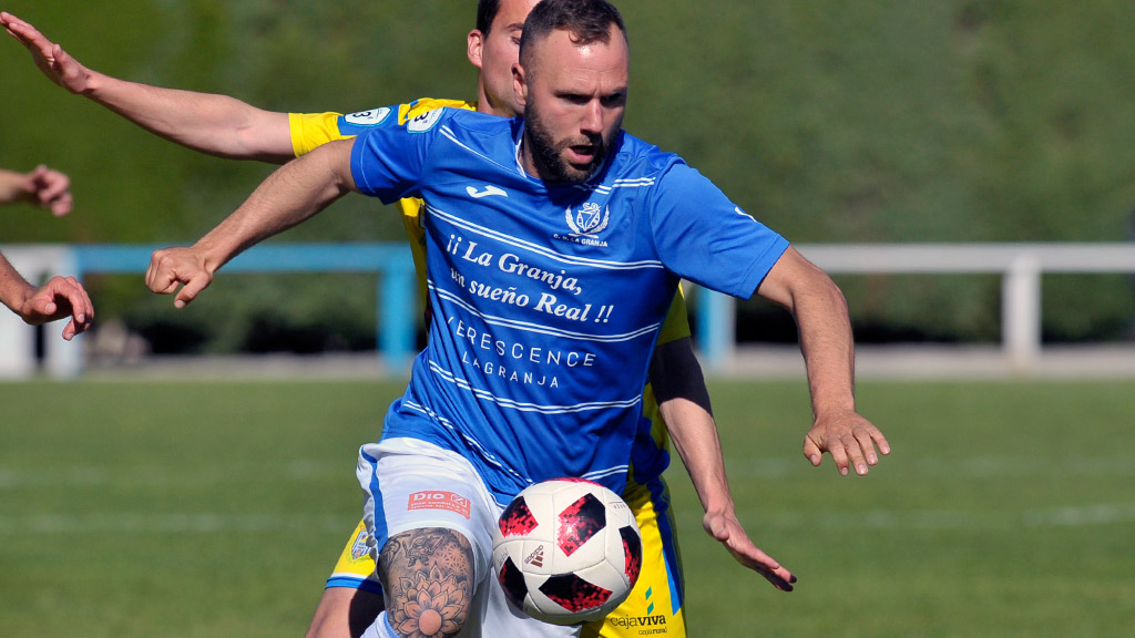 El centrocampista del CD La Granja Alberto Terleira controla un balón ante la presión de un rival. / KAMARERO