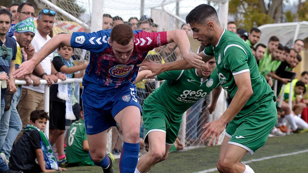 El delantero de la Gimnástica Segoviana Agus Alonso trata marcharse en velocidad de un rival del Churra. / JUAN MARTÍN - LA GIMNÁSTICA