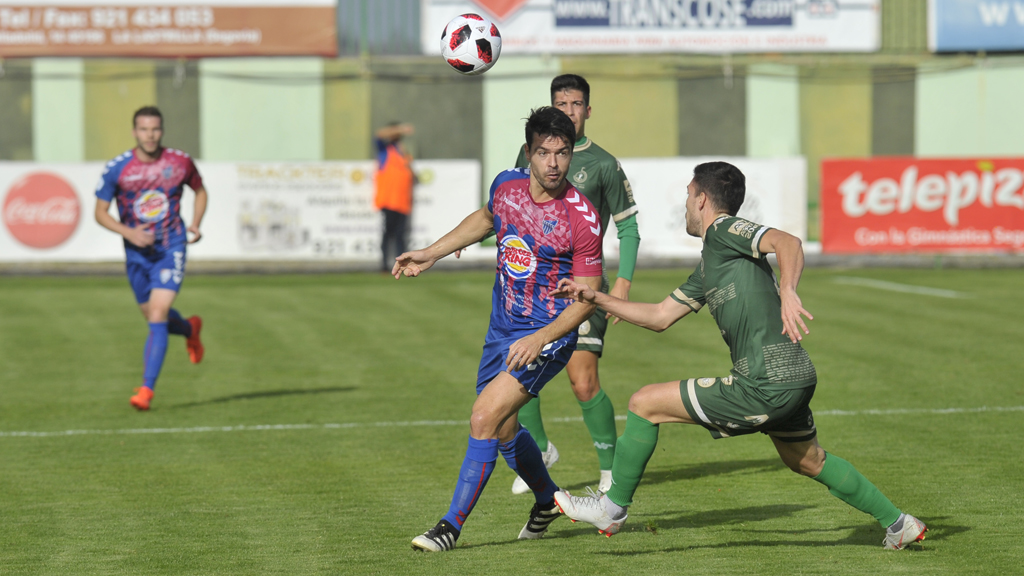 El centrocampista de la Segoviana Domingo Pérez protege un balón por alto ante la presión del Astorga. / KAMARERO