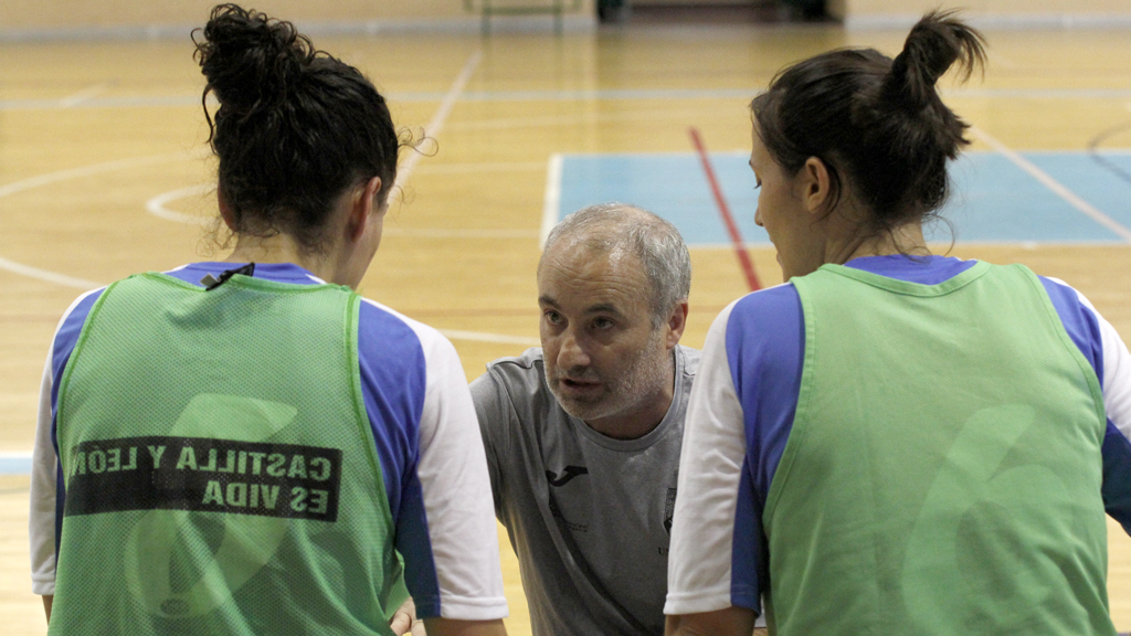 El técnico Luis Martín da instrucciones a dos jugadoras del Unami durante un tiempo muerto en un partido. / NEREA LLORENTE